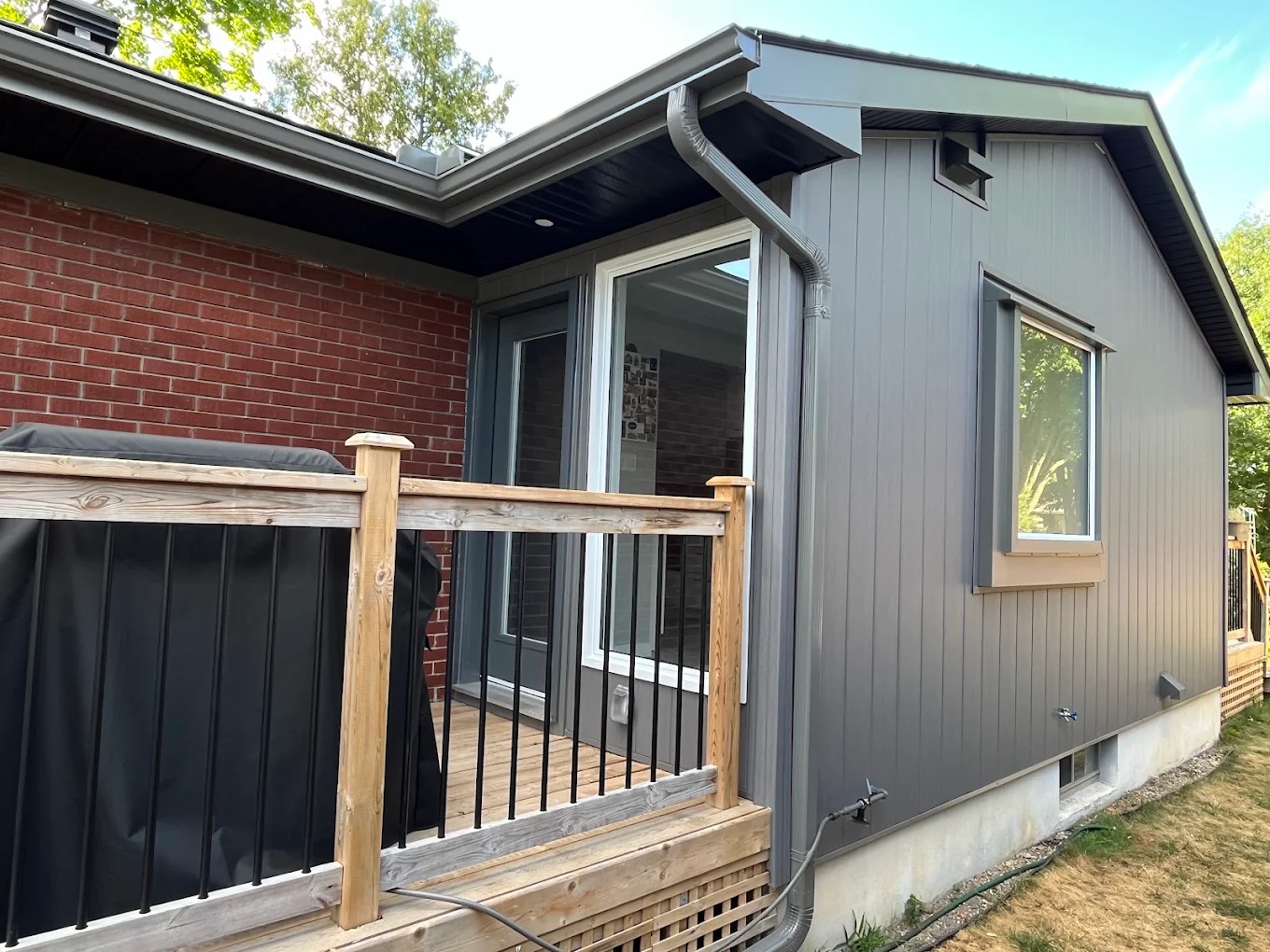 Completed dark vertical siding installation on an Ottawa home addition by Kaloozie Comfort
